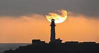 Sun sets behind the Pigeon Point Lighthouse in California