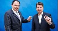 Finanz- und Heimatsstaatssekretär Martin Schöffel und Innenstaatssekretär Sandro Kirchner mit der Sammlermünze „Polizei“
