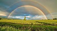 Free Crop Field Under Rainbow and Cloudy Skies at Dayime Stock Photo