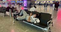 Holidaymakers hunker down for the night at Heathrow after torrential rain and storms across the Atlantic forced dozens of flights to be cancelled
