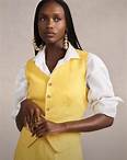 Woman wears yellow linen suit vest and trousers.