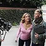 Alex, played by Bryan Fox, walks toward camera with the Nosey Neighbor, played by Kelly Preston.
